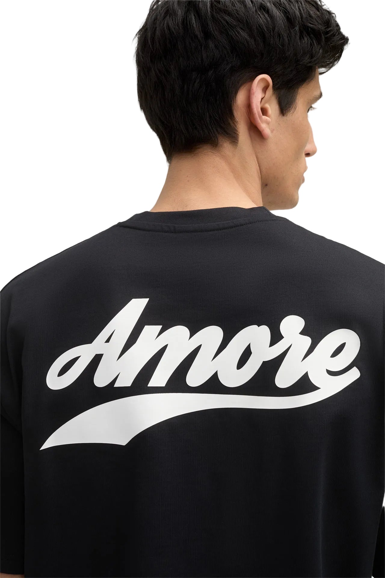 Person wearing a black shirt with 'Amore' printed on the back against a gray background