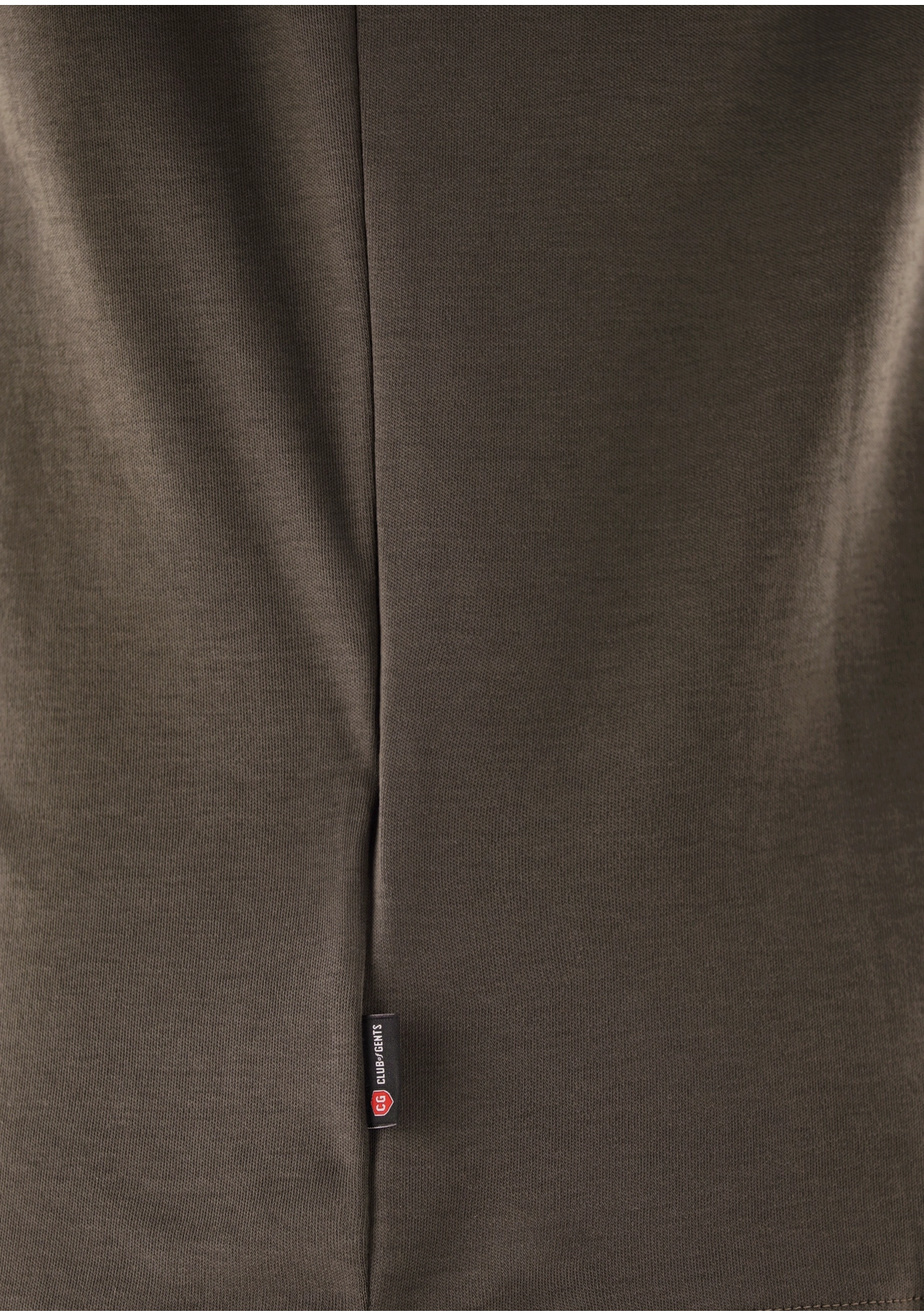 Close-up of a brown fabric with a brand label on a dark background